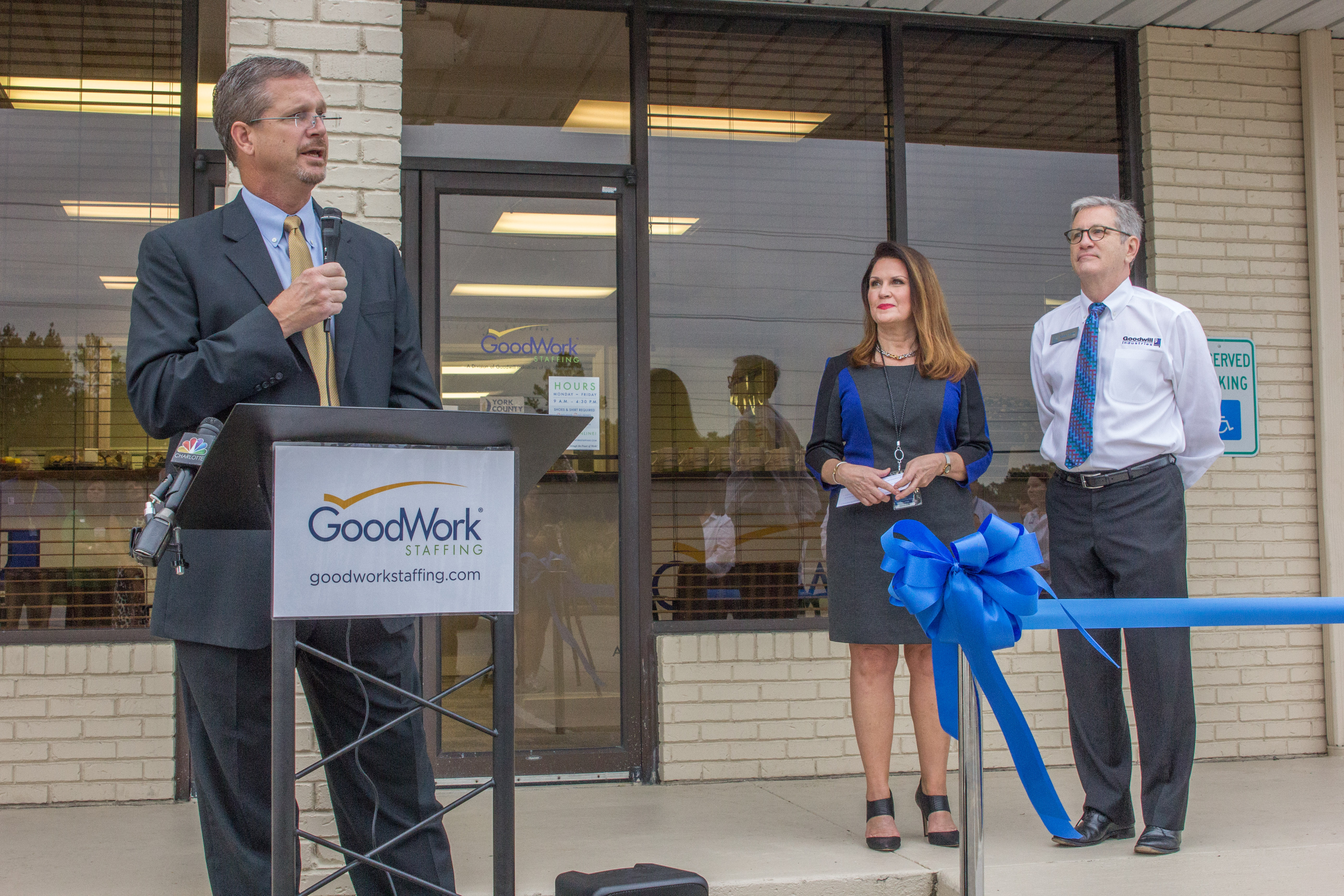 Rob Youngblood, York County Regional Chamber President (left), addresses the crowd gathered for the grand opening of the GoodWorks Staffing location in Rock Hill, SC, along with Carol Ashby, Dir. of GoodWork Staffing (center), and Robin Carson, Senior VP of Goodwill Industries.