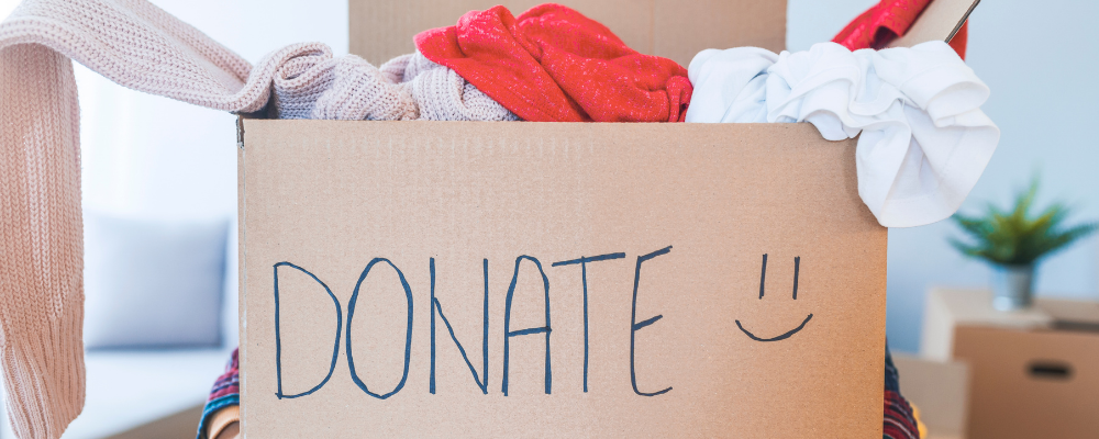 Cardboard box labeled "donate" filled with clothes