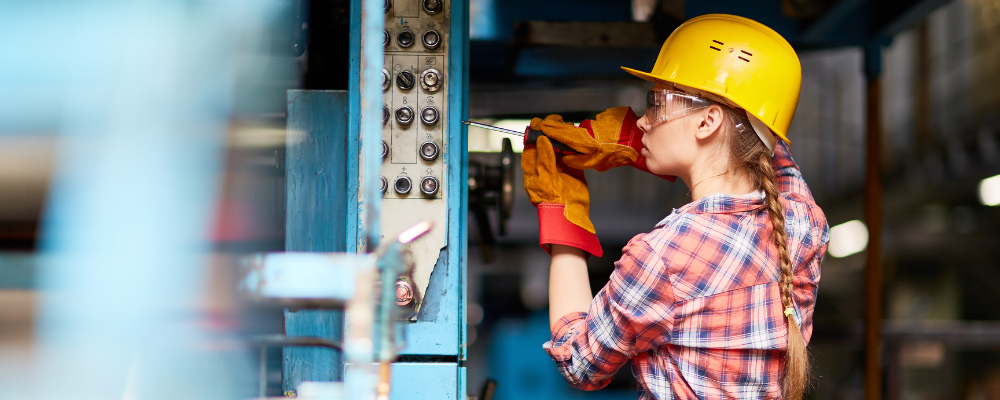 A stock image of a young female electrician opening an electrical box while taking an electrical training course